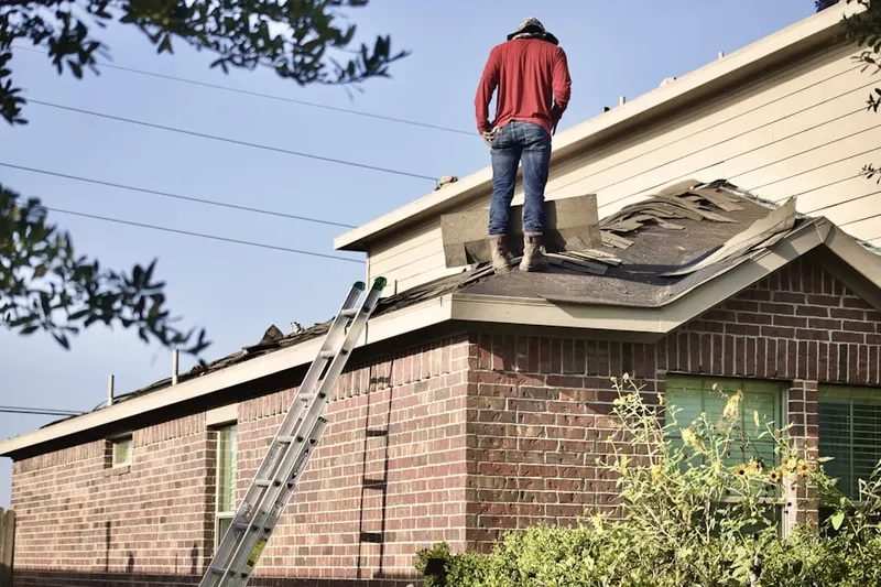 Professional roofer working on a residential roof in Chenaults Shop